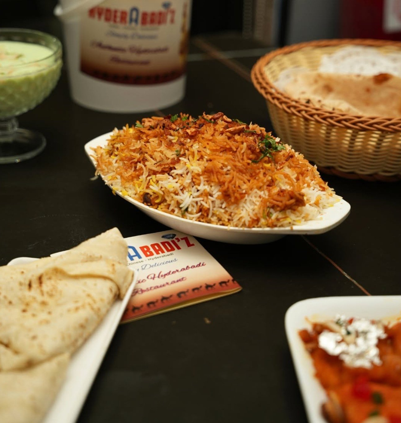 Hyderabadi biryani served with bread and accompaniments